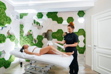 Genç ve güzel bir kız modern bir güzellik salonunda kozmetoloji ameliyatı yapıyor. Güzellik salonunda spa prosedürleri