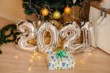 Sevimli gülümseyen bebek, Noel ağacının altında yatıyor ve hediyelerle oynuyor. Noel ve Yeni Yıl kutlamaları