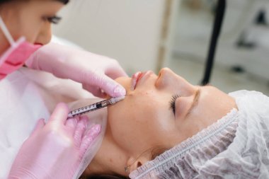 Genç ve güzel bir kız için biyo-evrizasyon ve kırışıklıkların giderilmesi için kozmetik prosedür. Kozmetoloji