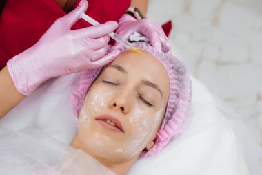 Genç ve güzel bir kız için biyo-evrizasyon ve kırışıklıkların giderilmesi için kozmetik prosedür. Kozmetoloji