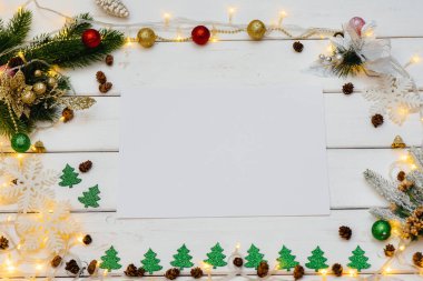 Beyaz Noel arkaplanı şenlikli dekorlar, fenerler, kar taneleri ve Noel ağacı dallarıyla süslenmiş. Noel tebrik kartı. Kış tatili. Mutlu yıllar.