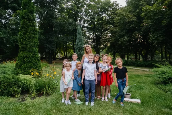 A teacher teaches a class of children in an outdoor Park. Back to school, learning during the pandemic