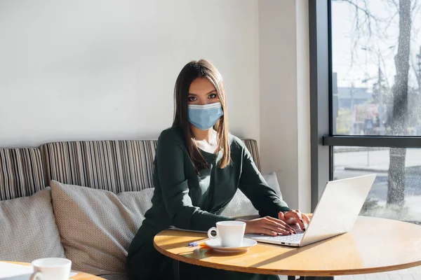 Ein Junges Mädchen Sitzt Mit Maske Einem Café Und Arbeitet — Stockfoto