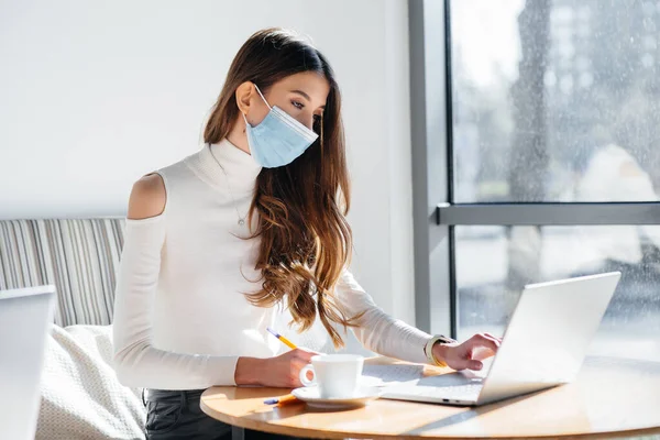 Una Joven Está Sentada Café Usando Una Máscara Trabajando Una — Foto de Stock