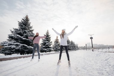 Güneşli bir kış gününde koşmadan önce iki genç atletik kız ısınma egzersizi yapıyor. Sağlıklı bir yaşam tarzı.