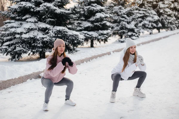 两个年轻的女运动员在阳光灿烂的冬日跑步前做了热身运动 健康的生活方式 — 图库照片