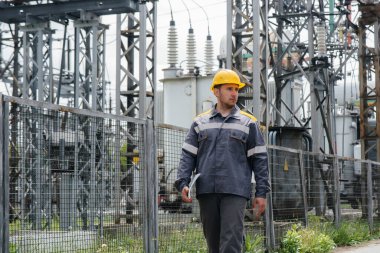 Bir mühendis modern bir elektrik santralini gezip teftiş ediyor. Enerji. Sanayi