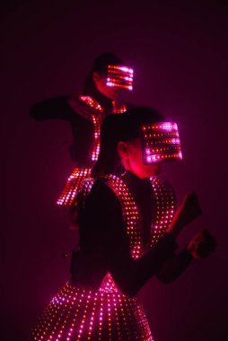 UV kostümlü iki seksi disko dansçısı. Partiler ve danslar.