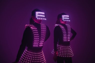 UV kostümlü iki seksi disko dansçısı. Partiler ve danslar.