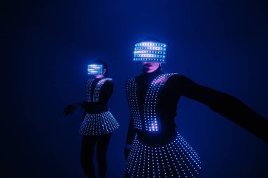 UV kostümlü iki seksi disko dansçısı. Partiler ve danslar.