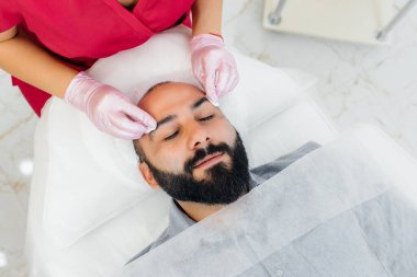Genç bir adam estetik yüz soyma ameliyatı oluyor. Kozmetoloji ve Gençleştirme