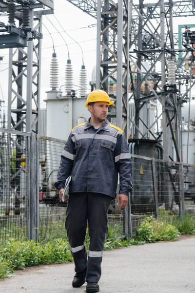 An engineering employee makes a tour and inspection of a modern electrical substation. Energy. Industry