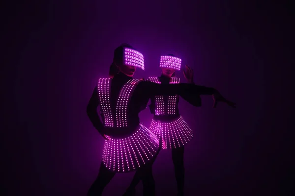 UV kostümlü iki seksi disko dansçısı. Partiler ve danslar.
