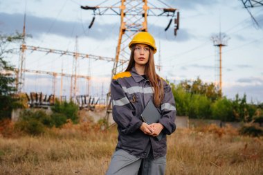 Genç bir mühendis, elektrik hattının ekipmanlarını denetleyip kontrol ediyor. Enerji