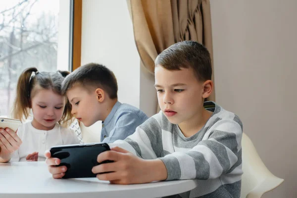 Bambini Siedono Tavolo Caffè Giocano Insieme Telefoni Cellulari Intrattenimento Moderno — Foto Stock