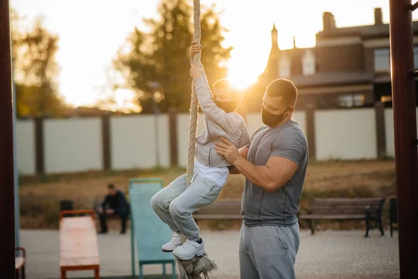 Padre Ayuda Hijo Trepar Una Cuerda Campo Deportes Con Máscaras — Foto de Stock