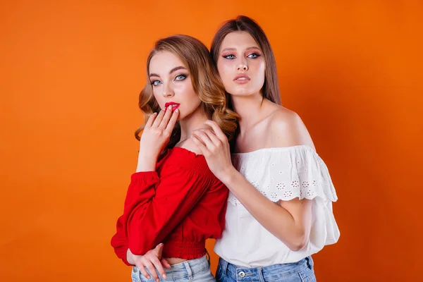 Twee Jonge Mooie Meisjes Tonen Emoties Glimlachen Studio Een Oranje — Stockfoto