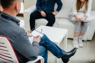 Genç evli bir çift terapi seansında bir psikologla konuşuyor. Psikoloji.