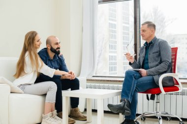 Genç, mutlu, evli bir çift terapi seansında bir psikologla konuşuyor. Psikoloji.