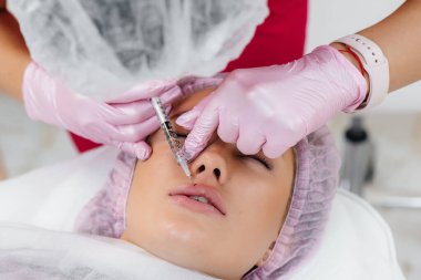 Genç ve güzel bir kız kozmetolojisi için dudak büyütme ve kırışıklık giderme prosedürü