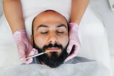 Dudak büyütme ve sakallı bir adam için kırışıklık giderme için estetik ameliyat. Kozmetoloji