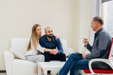 Genç, mutlu, evli bir çift terapi seansında bir psikologla konuşuyor. Psikoloji.