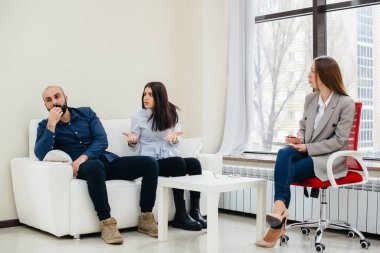 Genç evli bir çift terapi seansında bir psikologla konuşuyor. Psikoloji.