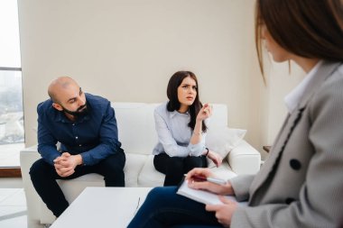 Genç evli bir çift terapi seansında bir psikologla konuşuyor. Psikoloji.