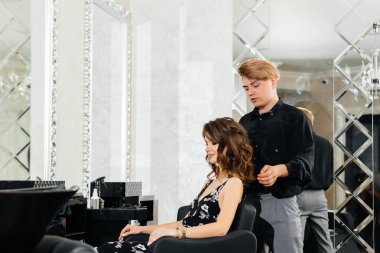 Güzel, modern bir güzellik salonunda, profesyonel bir stilist genç bir kız için saç ve saç kesimi yapar. Güzellik ve moda.