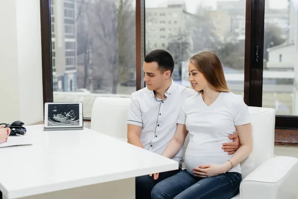 A young couple at a gynecologist\'s consultation after an ultrasound. Pregnancy, and health care