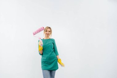 Genç bir kız beyaz bir duvarın önünde tekerlekli sandalyeyle poz veriyor. İç kısmın tamiri.