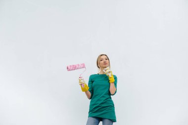 Genç bir kız beyaz bir duvarın önünde tekerlekli sandalyeyle poz veriyor. İç kısmın tamiri.