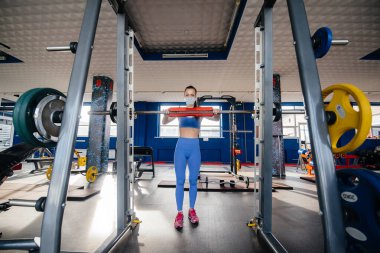 Salgın sırasında spor salonunda maske takan genç ve güzel bir kız. Halka açık yerlerde sosyal mesafeler.