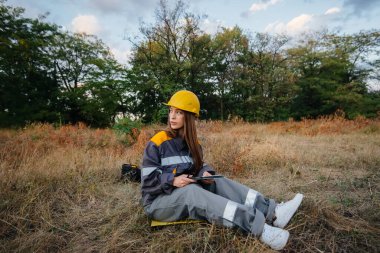 Genç bir mühendis, elektrik hattının ekipmanlarını denetleyip kontrol ediyor. Enerji