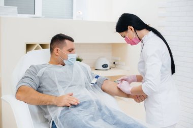 Bir adamın kanı analiz etmek ve virüsleri test etmek için bir damardan alınır. Bağışıklık sisteminin ve antikorların oluşumu.