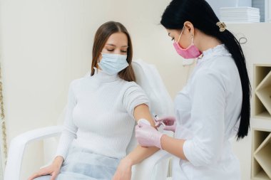 Dünya çapında bir salgın sırasında grip ve koronavirüs enfeksiyonuna karşı bir kızın aşısı. Bağışıklık sisteminin ve antikorların oluşumu.