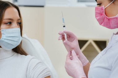 Dünya çapında bir salgın sırasında grip ve koronavirüs enfeksiyonuna karşı bir kızın aşısı. Bağışıklık sisteminin ve antikorların oluşumu.