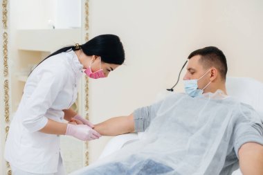 Bir adamın kanı analiz etmek ve virüsleri test etmek için bir damardan alınır. Bağışıklık sisteminin ve antikorların oluşumu.