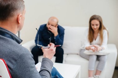 Genç evli bir çift terapi seansında bir psikologla konuşuyor. Psikoloji.