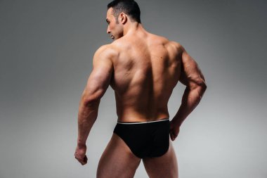 Genç bir sporcu stüdyoda üstsüz poz veriyor. Spor..