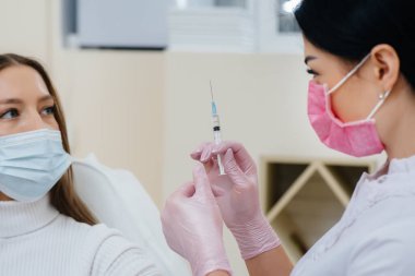 Dünya çapında bir salgın sırasında grip ve koronavirüs enfeksiyonuna karşı bir kızın aşısı. Bağışıklık sisteminin ve antikorların oluşumu.