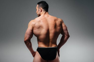 Genç bir sporcu stüdyoda üstsüz poz veriyor. Spor..