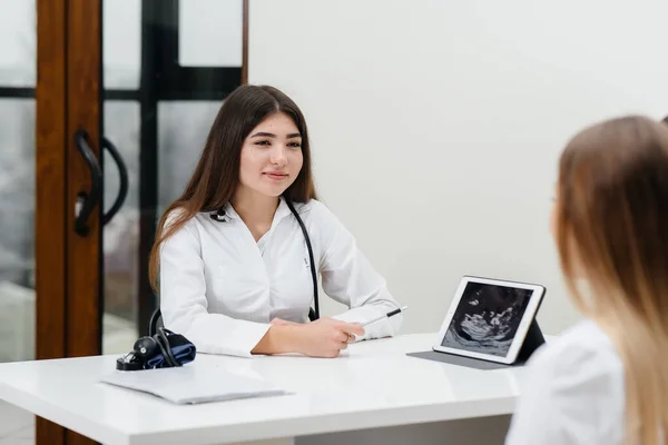 A young couple at a gynecologist\'s consultation after an ultrasound. Pregnancy, and health care