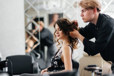 Güzel, modern bir güzellik salonunda, profesyonel bir stilist genç bir kız için saç ve saç kesimi yapar. Güzellik ve moda.