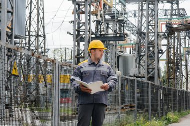 Enerji mühendisi istasyonun ekipmanlarını inceler. Güç mühendisliği. Sanayi