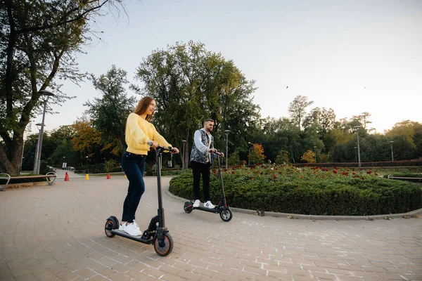 Mladý Krásný Pár Jezdí Elektrických Skútrech Parku Teplého Podzimního Dne — Stock fotografie