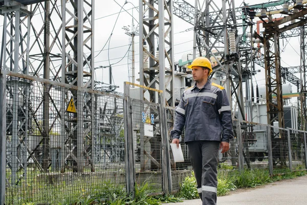 An engineering employee makes a tour and inspection of a modern electrical substation. Energy. Industry