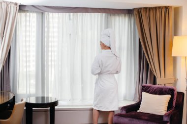 Beyaz önlüklü güzel bir kız otel odasında kahve içiyor..