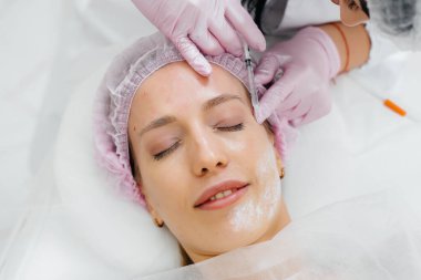 Genç ve güzel bir kız için biyo-evrizasyon ve kırışıklıkların giderilmesi için kozmetik prosedür. Kozmetoloji.