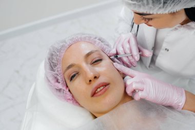 Genç ve güzel bir kız için biyo-evrizasyon ve kırışıklıkların giderilmesi için kozmetik prosedür. Kozmetoloji.